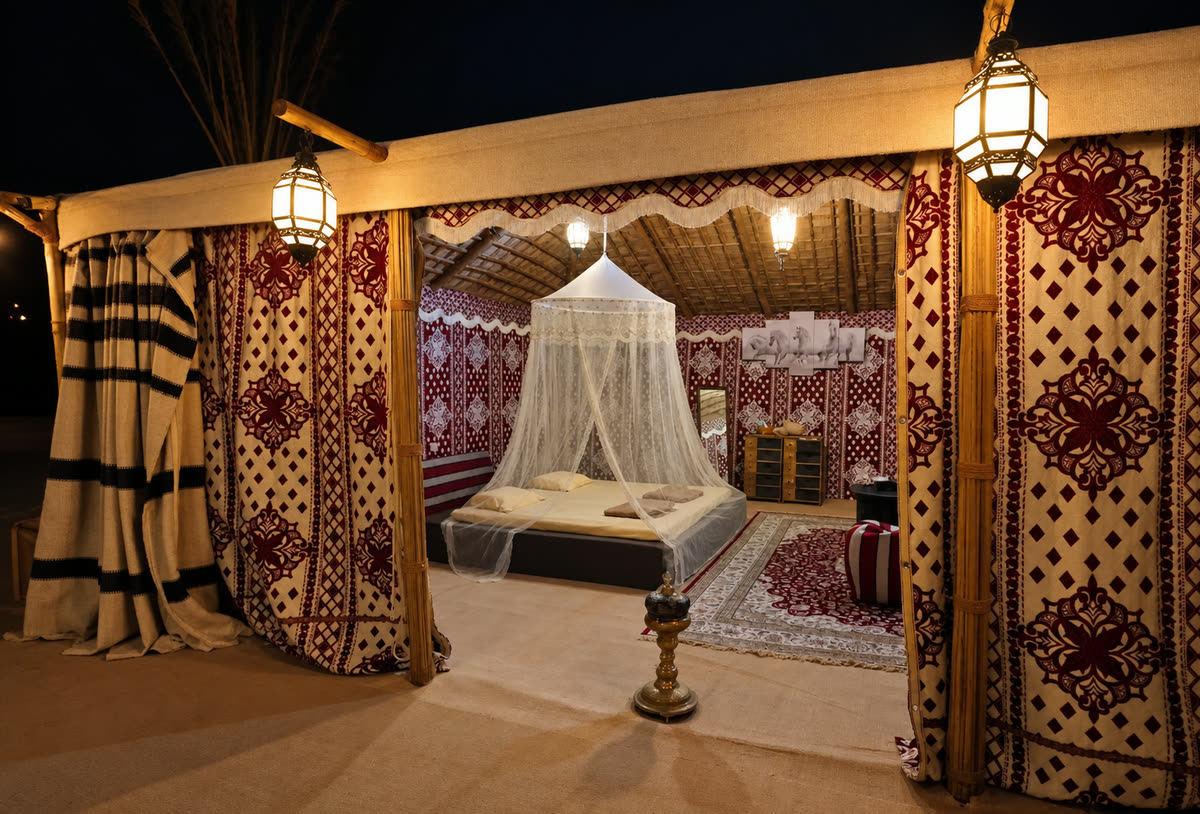 An ornately decorated private desert tent interior with a canopied bed and patterned textiles