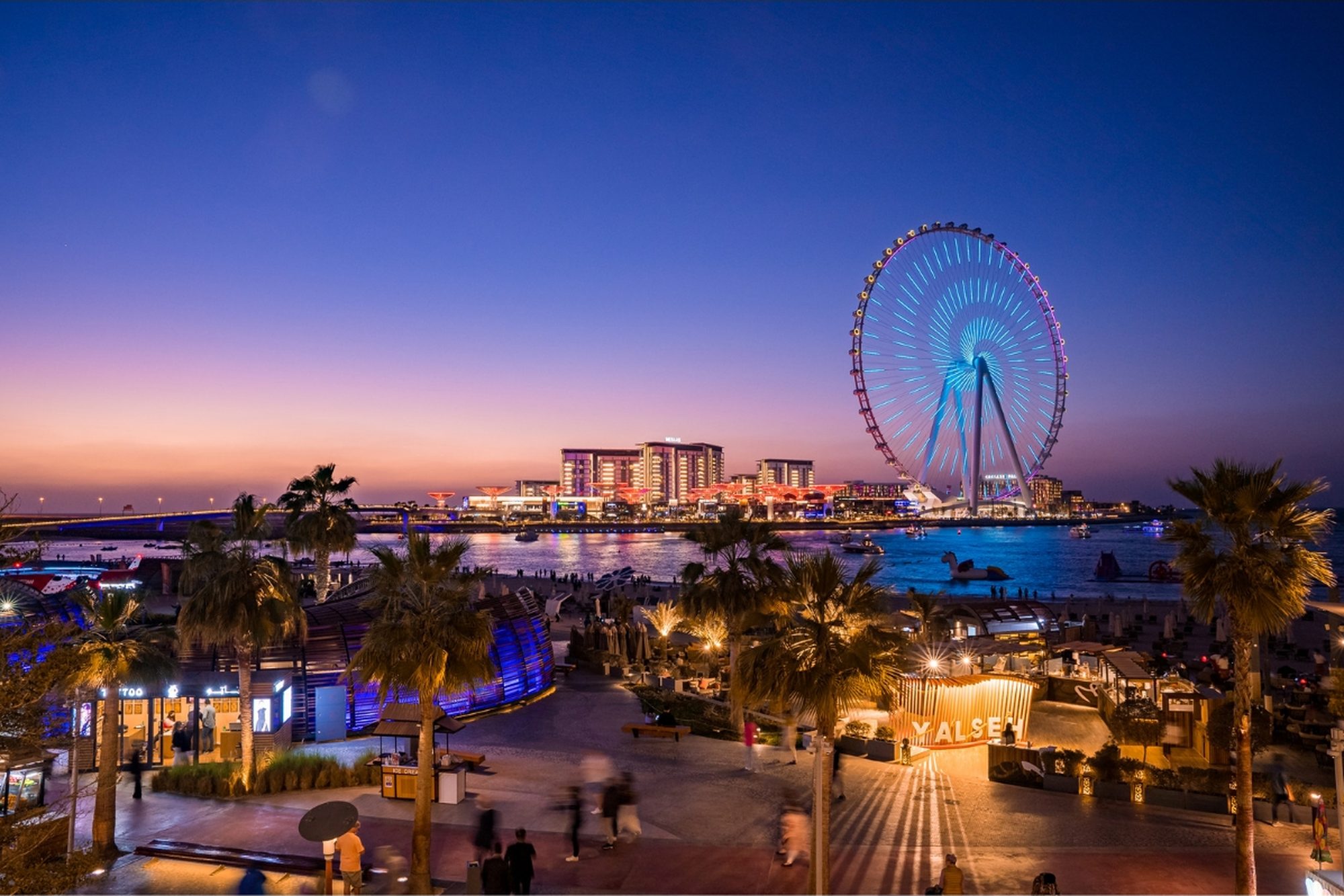 Bluewaters Island and Ain Dubai glowing over the water at dusk in Dubai.