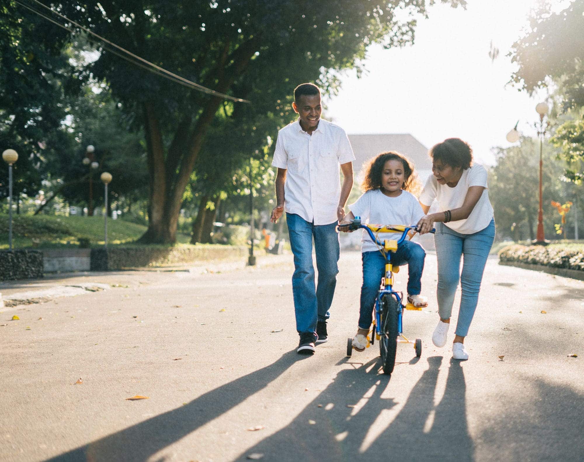 A family walking together outdoors, parents and children moving at an easy, unhurried pace.