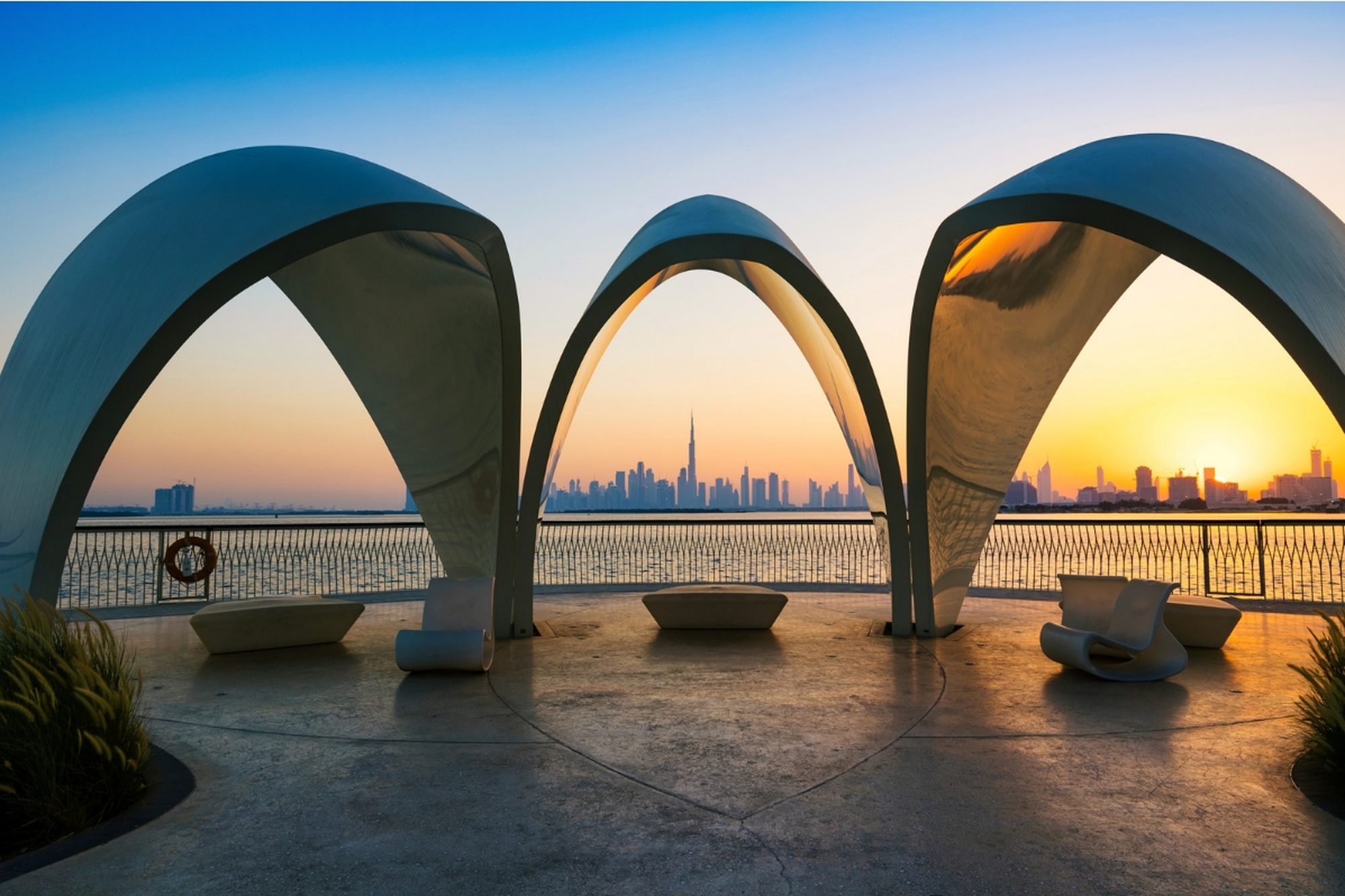 The illuminated arches of Dubai Water Canal reflected at sunset.